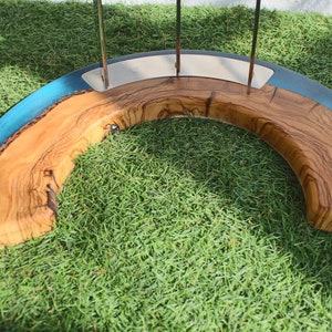 K&ouml;nnte beinhalten: Eine Holzschale mit einer blauen Harzeinlage. Die Schale ist halbmondf&ouml;rmig und hat eine nat&uuml;rliche Holzoptik. Die Schale steht auf einem Bett aus gr&uuml;nem Gras.