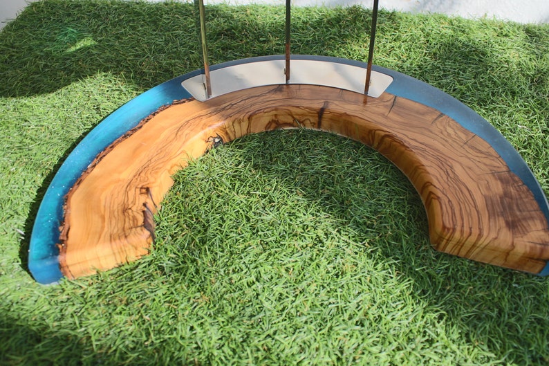 K&ouml;nnte beinhalten: Eine Holzschale mit einer blauen Harzeinlage. Die Schale ist halbmondf&ouml;rmig und hat eine nat&uuml;rliche Holzoptik. Die Schale steht auf einem Bett aus gr&uuml;nem Gras.