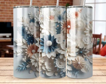 Op de afbeelding: Drie roestvrijstalen bekers met een bloemenontwerp. Het ontwerp bevat witte, blauwe en perzikkleurige papieren bloemen.