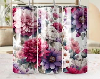 Op de afbeelding: Drie roestvrijstalen bekers met bloemmotieven. De bekers hebben een verscheidenheid aan bloemen in roze, paarse en witte tinten tegen een witte achtergrond. Elke beker heeft een zilveren rietje.