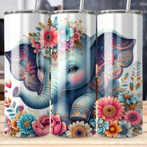 May include: Three stainless steel tumblers with a white background and a colorful floral design. The center tumbler features a blue elephant with a floral crown and paisley patterned ears. The tumblers are perfect for holding hot or cold beverages.