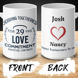 May include: White ceramic mug with a blue design that says "Cherishing Togetherness for 29 yrs Love Commitment Adventure Continues". The back of the mug has a red heart and says "Josh Nancy Happy Anniversary to us".