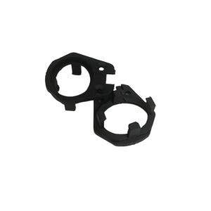 Puede incluir: Anillo de plástico negro con una abertura circular y una abertura más pequeña en el lateral. El anillo está diseñado para sujetar un objeto redondo, como una tapa de botella.