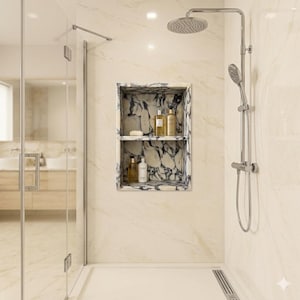 Op de afbeelding: Een moderne badkamer met een marmeren douchenis en een glazen douchedeur. De douche heeft een regendouchekop en een handdouche. De nis bevat diverse flessen badproducten. De muren zijn licht marmer.