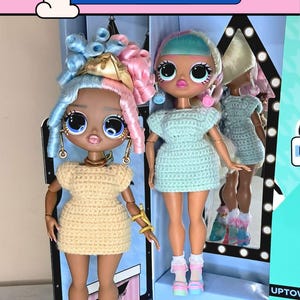 以下が含まれることがあります： かぎ針編みのドレスを着た2体の人形が箱の中に展示されています。1体は薄い黄色のドレス、金のジュエリー、ピンクの靴下を着用しています。もう1体は水色のドレスとピンクと青の靴を着用しています。「PDF Crochet Pattern for doll」と「CROCHET DRESS」の文字が見えます。