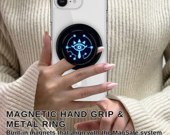 May include: A clear phone case with a black magnetic hand grip and metal ring attached. The grip features a blue glowing eye design. The text "MAGNETIC HAND GRIP & METAL RING" is visible, along with "Built-in magnets that align with the MagSafe system."