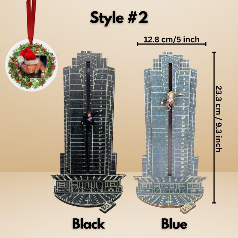 May include: A black and a blue skyscraper-shaped advent calendar, 9.3 inches tall and 5 inches wide, with a figure climbing the building. The base reads "HAKATOM". A Christmas ornament with a photo of a person wearing a Santa hat is also shown.