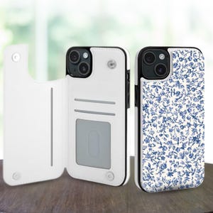 May include: A white phone case with a blue floral pattern and a black trim. The case is shown open, revealing card slots, and closed. The phone case is designed to protect the phone and hold cards.