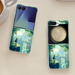 May include: Two open flip phones with matching cases. The cases feature a fantasy landscape with a figure standing on a cliff, a bridge, and a mountain range. The phone screens are visible, one with a blue gradient and the other with a planet image.