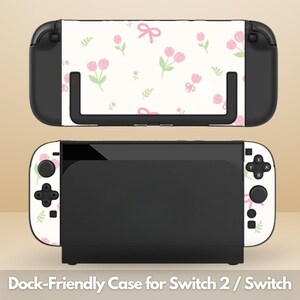 Può includere: Una console e un dock Nintendo Switch in bianco e nero. La console ha una cover bianca con un motivo floreale rosa di tulipani e fiocchi. Il testo in basso recita "Dock-Friendly Case for Switch 2 / Switch".