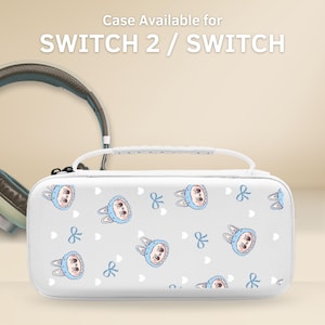 Può includere: Custodia bianca per Switch 2 / Switch con un motivo ripetuto di coniglietti dei cartoni animati con cappelli e fiocchi blu. La custodia ha un manico bianco e una chiusura a cerniera. Il testo "Case Available for SWITCH 2 / SWITCH" è in alto.