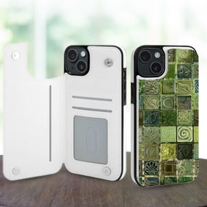 Può includere: Custodia per telefono in pelle bianca con bordo nero, con design a portafoglio. La custodia del telefono a destra ha un motivo a piastrelle verdi con vari disegni ispirati alla natura. Le custodie per telefoni sono su una superficie di legno.