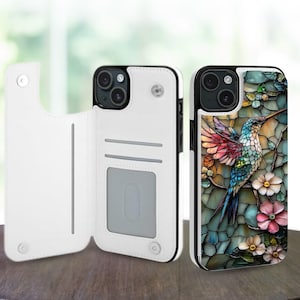 Puede incluir: Funda de teléfono de cuero blanco con función de cartera, junto a una funda de teléfono con un colorido diseño de colibrí. El colibrí está posado en una rama con flores, sobre un fondo de estilo vidriera.