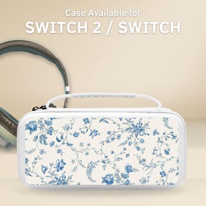 Puede incluir: Funda blanca para Switch 2 / Switch con un estampado floral azul. La funda tiene un asa y un cierre de cremallera. El texto "Case Available for SWITCH 2 / SWITCH" está en la parte superior.