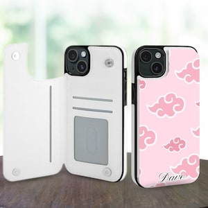 Peut inclure: Deux coques de téléphone. L'une est blanche avec un design portefeuille, l'autre est rose avec un motif de nuages et le nom "Dave" en cursive. Les deux coques ont des bords noirs et une découpe pour l'appareil photo.
