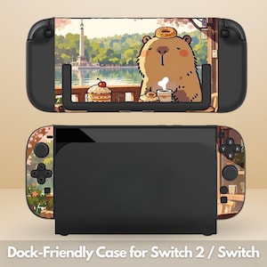 May include: Black dock-friendly case for Switch 2 / Switch with a colorful design. The case features a cartoon bear with a donut on its head, enjoying a cup of coffee. The background shows a lake and a building. The text "Dock-Friendly Case for Switch 2 / Switch" is at the bottom.