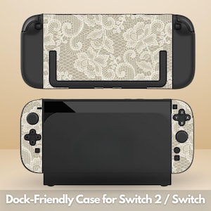 May include: A gaming console dock and handheld unit featuring a beige and white floral lace pattern skin. The console includes black controllers with matching lace decals on the front panels and a black dock with a lace-covered front panel.