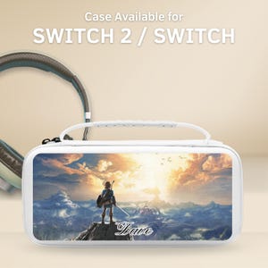Könnte beinhalten: Weißes Switch 2 / Switch-Etui mit Griff, mit einem Landschaftsbild eines Charakters auf einem Berg. Auf dem Etui steht der Name "Dave". Ein Headset ist im Hintergrund zu sehen.