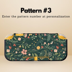 May include: A dark green patterned case for a handheld gaming device. The case features a floral design with pink, yellow, and white flowers, butterflies, and bees. The text "Pattern #3" and "Enter the pattern number at personalization" are visible.