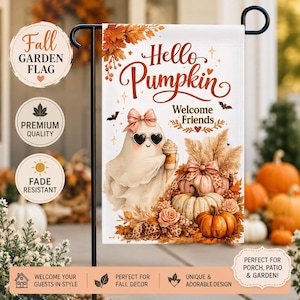 以下が含まれることがあります： Hello PumpkinとWelcome Friendsの文字が入った長方形のガーデンフラッグ。ピンクのリボンとハート型のサングラスを身につけコーヒーカップを持った白い幽霊が、オレンジ色のカボチャや秋の葉に囲まれているデザインです。