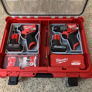 May include: Red Milwaukee toolbox containing two cordless drills, one with a hammer drill and one with a driver bit, and two batteries. The box has a Milwaukee logo on the front.
