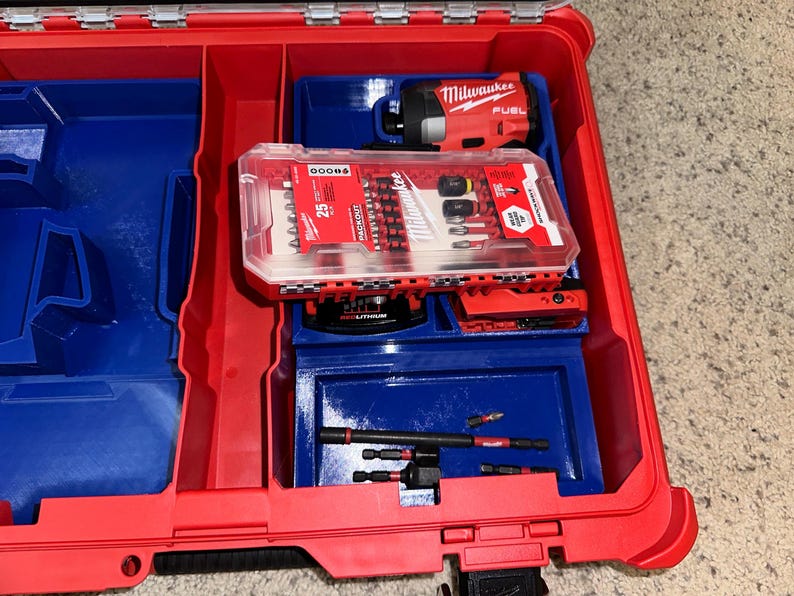 May include: A red and blue tool box with a Milwaukee FUEL drill and a clear plastic case of 25 screwdriver bits inside.
