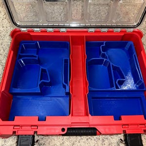 May include: Red and blue plastic tool box with a removable insert. The insert has two compartments with custom cutouts for tools.