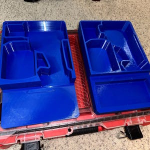 May include: Two blue plastic organizers with compartments for tools or other small items. The organizers are sitting in a red toolbox.