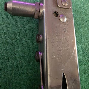 May include: A silver Craftsman rivet tool with the text "SEARS CRAFTSMAN 74770" stamped on the side. The tool has a black handle and is set against a green background.