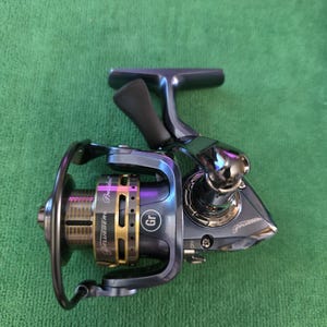 May include: A Pflueger President spinning fishing reel in a metallic blue finish with gold-toned accents on the spool. The reel features a black handle knob, a bail arm, and the text Pflueger President and Gr printed on the side of the body.