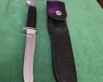 Buck hunting knife model 105 with 5" blade, black phenolic handle and leather sheath. The Buck knife is made in USA.