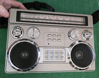 QFX 3-band AM/FM/sw, 3 way power, 2-lights, several inputs Portable Radio with carrying strap. The Radio works as it should.