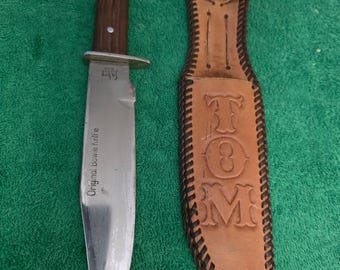 Sabre Bowie model #631 1970's hunting knife with 6" blade wood handle and leather sheath. The hunting knife made in Japan.