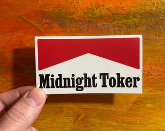 May include: White sticker with a red and white cigarette logo and the text "Midnight Toker" in black.
