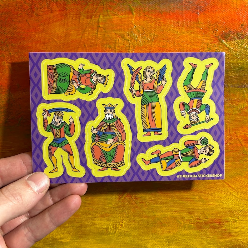 May include: A set of six colorful stickers featuring illustrations of playing card characters. The characters are a king, queen, jack, and three jesters. The stickers are on a purple background with yellow borders. The text "@thelocalstickershop" is at the bottom of the sheet.