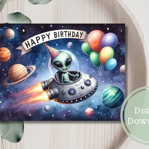 Op de afbeelding: Een digitale download van een verjaardagskaart met een groene alien in een ruimteschip dat door de ruimte vliegt met planeten en ballonnen. De kaart zegt "Happy Birthday".