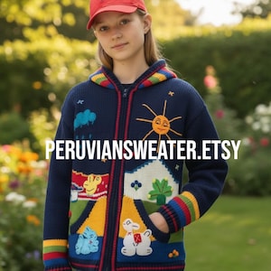 May include: A navy blue zip-up hooded sweater with colourful embroidered designs, including a smiling sun, clouds, and animals. The sweater has rainbow striped cuffs and trim. The text "PERUVIANSWEATER.ETSY" is displayed on the front.