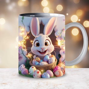 Op de afbeelding: Witte keramische mok met een kleurrijk ontwerp van een paashaas en eieren. De haas kijkt uit een mandje met kleurrijke eieren.