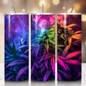 May include: Three stainless steel tumblers featuring colourful cannabis leaf designs with a rainbow smoke effect. Each tumbler is the same size and shape, but with a different colour scheme. The first tumbler has a blue and purple colour scheme, the second tumbler has a green and pink colour scheme, and the third tumbler has a red and orange colour scheme.