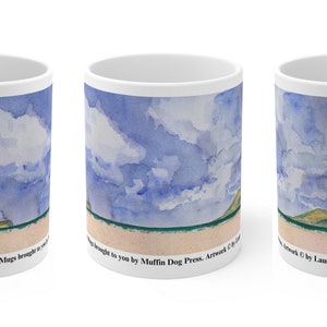 May include: White ceramic mug featuring a watercolour painting of a beach scene with blue sky, white clouds, and green hills. The text "Dovanagly Beach. Mugs brought to you by Muffin Dog Press. Artwork © by Laura Harrison McBride" is printed on the mug.