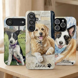 Pode incluir: Três capas retangulares para telemóvel com ilustrações em aguarela de cães. A capa da esquerda mostra um cão preto e branco com uma coleira roxa. A central representa um cão dourado com o nome Lana e uma pata. A da direita mostra um cão castanho e branco com uma bandana azul e o nome Stella.