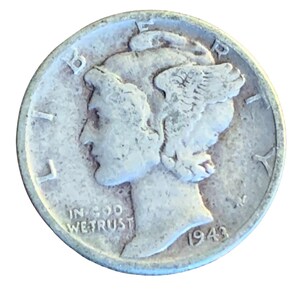 May include: A silver Mercury dime from 1943. The coin shows a profile of a woman with winged hair, the word "LIBERTY" above, and "IN GOD WE TRUST" below. The year "1943" is visible.