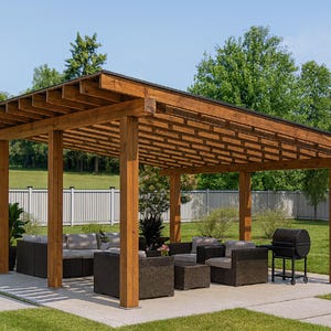 Puede incluir: Una pérgola de madera con techo de listones proporciona sombra sobre un patio con muebles de exterior. Una parrilla negra se encuentra cerca. La estructura está rodeada de hierba verde y árboles, creando un espacio habitable al aire libre.