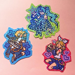 May include: Three die-cut holographic stickers featuring anime-style characters. One sticker shows a blue-haired figure on a green background, another shows a blonde figure with a keyboard on blue, and the third shows a blonde figure on red.