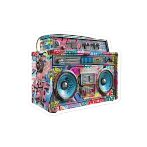 Pode incluir: Um boombox vintage coberto de grafites coloridos. O boombox tem duas colunas grandes, um leitor de cassetes e um sintonizador de rádio. Os grafites incluem palavras como "LOVE", "MUSIC" e "NYC".