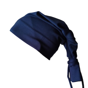 May include: A navy blue sleep cap with a long, pointed tail and tie closure. The cap is made of a soft, stretchy fabric and features a stitched seam across the forehead. The design is simple and functional, suitable for sleeping or lounging.