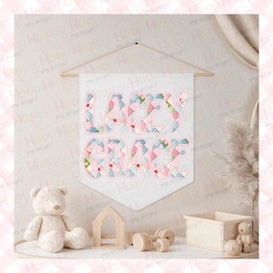 Puede incluir: Un cartel blanco con el nombre "LACEY GRACE" en letras de patchwork, colgado de una barra de madera. Las letras presentan dise&ntilde;os de patchwork rosa, azul y verde. Un oso de peluche, juguetes de madera y una peque&ntilde;a casa de madera est&aacute;n en primer plano.