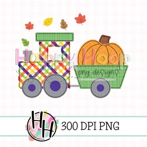 May include: A green and red plaid train with a pumpkin in the wagon. The train has two wheels and the wagon has one wheel. There are orange, yellow, and red leaves in the background.