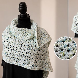 May include: A triangular crochet shawl featuring a variegated yarn pattern in shades of white, light blue, and pale green. The openwork stitch design creates a textured, lacy appearance. The shawl is displayed on a mannequin, showing its drape.