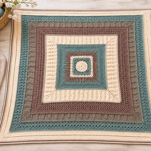 May include: A square crochet blanket featuring a central circle surrounded by concentric square borders in cream, teal, and brown. The design incorporates various textured stitch patterns, including ribbed and openwork sections, creating a geometric layered appearance.